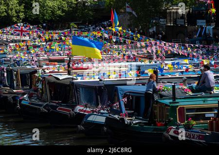 Londres, Royaume-Uni. 30 avril 2022. Le drapeau ukrainien est vu avec des bateaux étroits parés de banderoles colorées et d'autres décorations de style festival pendant l'Inland Waterways Association (IWA) Canalway Cavalcade à Little Venice pour célébrer le meilleur de la vie sur les cours d'eau à Londres et sa communauté. L’événement a lieu au début de la fin de semaine des fêtes de la Banque de mai et après avoir été annulé en raison de la pandémie, le thème de cette année est « Bienvenue de nouveau ». Credit: Stephen Chung / Alamy Live News Banque D'Images