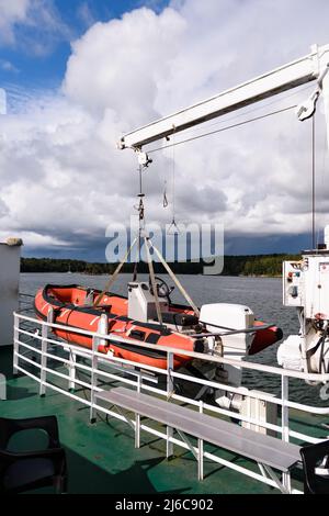 Un canot de sauvetage gonflable rouge avec moteur à bord d'un ferry dans l'archipel de Turku, en Finlande Banque D'Images