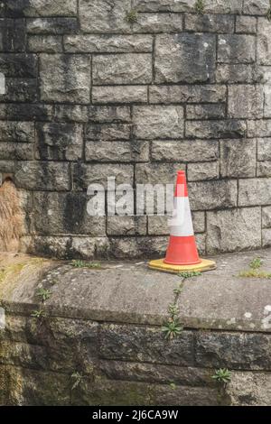 Le cône de la route mal placé est à gauche sur le socle d'un pont enjambant la rivière Fowey. Métaphore des feux de détresse. Banque D'Images