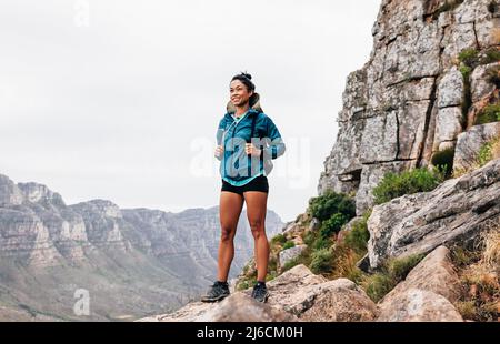 Jeune femme randonneur avec sac à dos debout sur la montagne appréciant la vue Banque D'Images