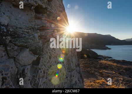 Morning Glory - ruines de l'ancienne tour de guet côtière Torre Argentina sur un rocher au-dessus de la côte ouest de la Sardaigne dans la mer Méditerranée au lever du soleil Banque D'Images
