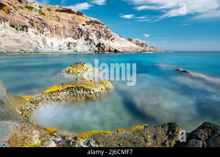 Beauté naturelle méditerranéenne - formations rocheuses dentelées et colorées dans les vagues de la mer Méditerranée bleu profond sur la côte ouest de la Sardaigne, Italie Banque D'Images
