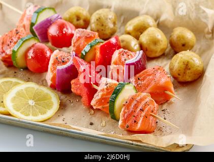 les brochettes de saumon et de légumes crus épicés se rapprochent de la lèchefrite Banque D'Images