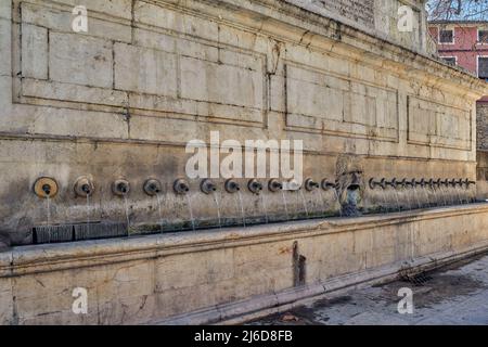 Fontaine murale avec une énorme cuvette et 25 tuyaux en bronze en forme de serpent et un marquage, en piquant de l'eau de l'embouchure du ressort Bellus. Xativa Banque D'Images