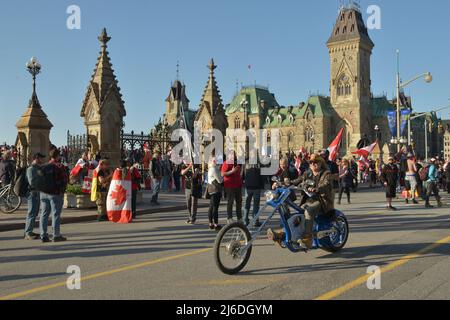 Le samedi 30 avril 2022, Ottawa Canada; le « Live from the Shed », « Freedom Fighters Canada » et « Veterans for Freedom » -- « Rolling Thunder Convoy » -- Memorial Event/Protest/Parade. Les vétérans ont prononcé des discours passionnés le matin, salués par des motos qui oraient. Les manifestants ont défilé sur la rue Elgin dans l'après-midi, sous la surveillance très étroite de la police. En plus petits nombres, les marcheurs se sont installés avec le soleil devant l'édifice du Parlement, présentant un festival comme une expérience de carnaval. Banque D'Images