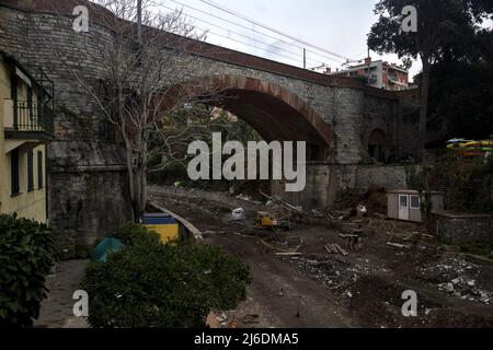 Ruisseau sec avec un pont en pierre au-dessus de lui par une journée nuageux Banque D'Images