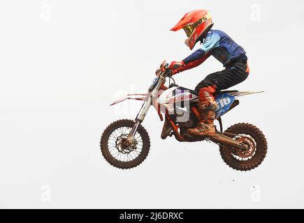 Jeune adolescent pendant une course de moto - saut, sport extrême Banque D'Images