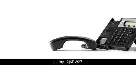 contactez-nous. téléphone voip de bureau noir avec combiné isolé sur fond blanc. Téléphonie VoIP concept pour la communication, contactez-nous et le client se Banque D'Images