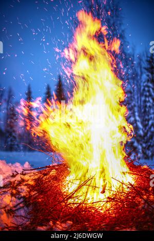 Grand feu dans un paysage d'hiver avec des étincelles volantes. Banque D'Images