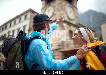 Youngcouple en imperméable marche dans les rues de la vieille ville le jour de la pluie Banque D'Images