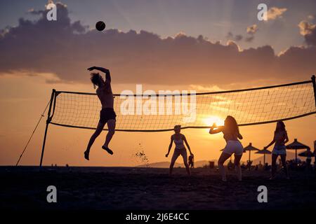 Volleyball sur la plage.jeunes amis jouant au volleyball sur la plage Banque D'Images