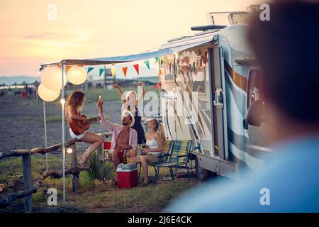 Groupe de jeunes amis heureux à côté de campeurs s'amuser pendant un voyage. Banque D'Images