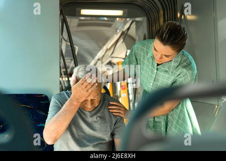 La jeune femme et l'homme âgé se sentent malades avec des symptômes de migraine dans les transports publics Banque D'Images