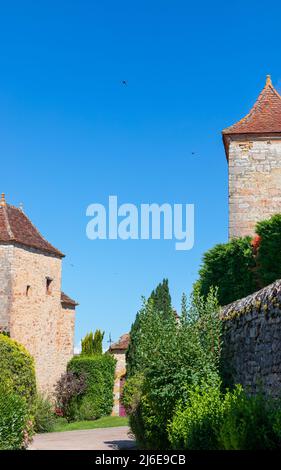 Bâtiments médiévaux en pierre dans le village de Loubressac. Forme de tours avec des toits de tuiles en pente et des jardins verts bien entretenus. Loubressac, Lot, Occitania Banque D'Images