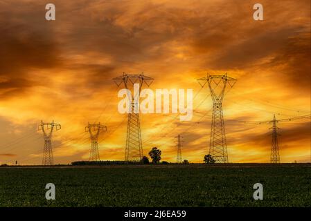 Lignes électriques haute tension, tours de transmission électrique haute tension sur ciel nuageux coloré au coucher du soleil, espace de copie Banque D'Images