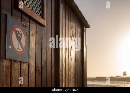 Gros plan d'un panneau interdisant l'entrée de conteneurs en verre sur la plage au coucher du soleil Banque D'Images