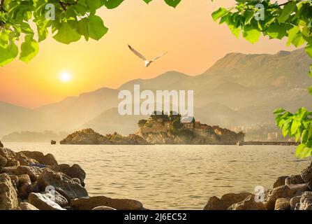 Sveti Stefan château sur une île de la mer au coucher du soleil Banque D'Images