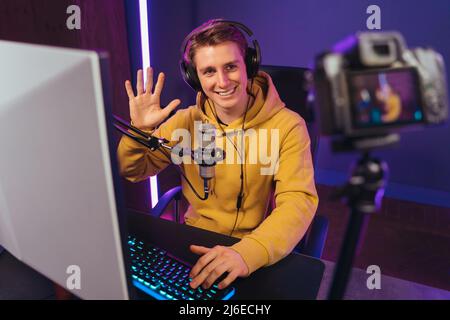 Pro gamer vlogger enregistrement vidéo sur l'appareil photo tout en jouant à des jeux vidéo la nuit Banque D'Images