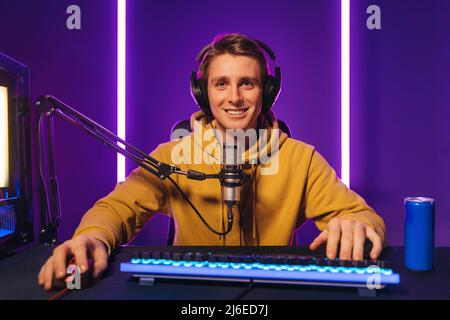 Un gamer professionnel heureux diffuse des vidéos en direct tout en appréciant le jeu Banque D'Images