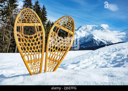 Paire de raquettes en bois dans la neige au-dessus des sommets de montagne Banque D'Images