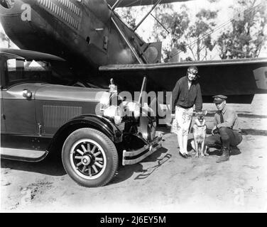 L'actrice de film silencieuse HAZEL KEENER à l'aérodrome militaire de Californie pose avec chien et officier militaire à côté de Bi-plane et Automobilecirca 1925 Banque D'Images