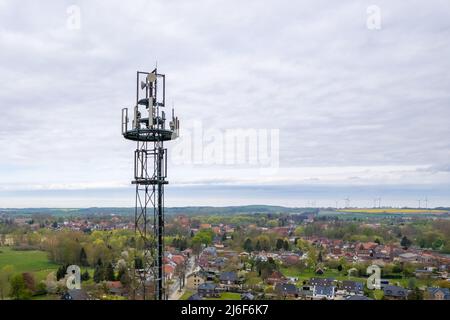 un mât radio avec antennes pour la communication mobile est situé dans une petite ville Banque D'Images