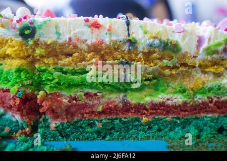Un gâteau savoureux et appétissant avec plusieurs couches de couleurs vives. Dessert sucré de fête. Gros plan. Banque D'Images