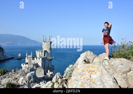 GASPRA, CRIMÉE – 04 JUIN 2019 : fille posant le Nest du château de Swallow sur un rocher à la mer Noire, Crimée, Russie. C'est un symbole et une attraction touristique de l'IRC Banque D'Images