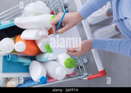 Femme achetant des détergents et de vérifier sa liste d'achats, vue de dessus Banque D'Images