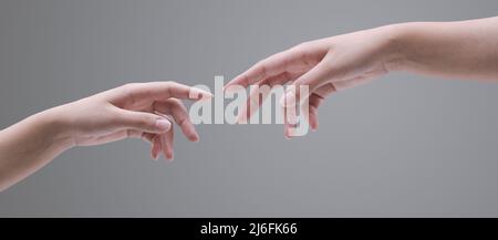 Les mains féminines se touchant sur fond gris, spiritualité et concept de connexion Banque D'Images