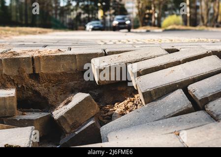 Trou sur la route des briques de trottoir. Danger sur la route pour les véhicules Banque D'Images