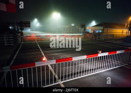 Un passage à niveau automatique à Barmouth, dans le nord du pays de Galles, par une nuit brumeuse. Banque D'Images