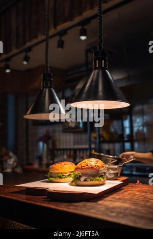 Deux délicieux hamburgers faits maison sur une table en bois. Banque D'Images