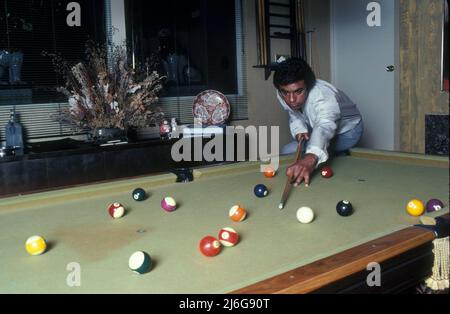 1 juillet 1981, Hollywood, Californie, Etats-Unis: Johnny MATHIS, chanteur de pop américain, 45 ans, jouant avec sa table de billard à la maison. John Royce Mathis (né le 30 septembre 1935) chanteur américain de musique populaire. Carrière artistique avec des célibataires de la musique standard, est devenu très populaire en tant qu'artiste d'album, avec plusieurs dizaines de ses albums atteignant le statut or ou platine et 73 faisant les graphiques Billboard. Vendu à ce jour plus de 400 millions de disques dans le monde entier, il est le troisième plus grand artiste vendeur du 20th siècle après Presley et Sinatra. A reçu le Grammy Lifetime Achievement Award et a été intronisé Banque D'Images