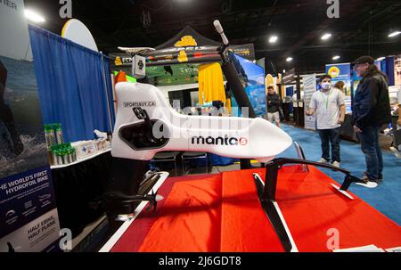 (220501) -- MISSISSAUGA, le 1 mai 2022 (Xinhua) -- Un homme regarde un vélo électrique hydrofoil lors du salon d'aventure en plein air 2022 à Mississauga, dans la région du Grand Toronto, au Canada, le 1 mai 2022. Cet événement annuel a eu lieu ici du vendredi au dimanche, avec les derniers équipements de camping, les sports de paddle, les vêtements d'extérieur, la plongée sous-marine et les destinations de voyage les plus prisées. (Photo de Zou Zheng/Xinhua) Banque D'Images