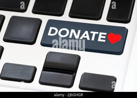 Bouton du clavier avec le mot Donate et un cœur rouge. Concepts : solidarité, soutien de causes caritatives, aide aux victimes de catastrophes, réfugiés, personnes de Banque D'Images