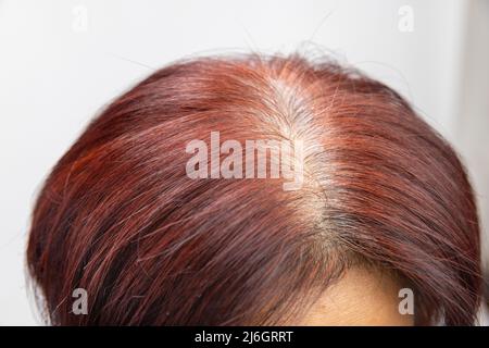 Femme asiatique d'âge moyen inquiétude au sujet des cheveux gris dans la ménopause. Banque D'Images