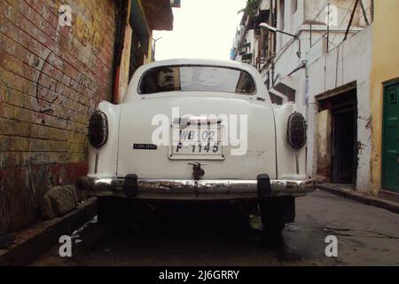 Une voiture blanche (l'ambassadeur de l'Hindustan) est garée dans une ruelle à Kolkata, dans le Bengale occidental, en Inde. Banque D'Images