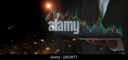 croissance boursière en hausse. Homme d'affaires tient une tablette et affiche un graphique holographique montrant les statistiques des graphiques rentables. Idées de planification de la croissance et Banque D'Images