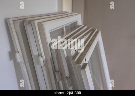 Collection d'anciennes fenêtres en bois utilisées prêtes à être prises à la décharge. Renouvellement de la maison, enlever les anciennes fenêtres pour en installer de nouvelles. Banque D'Images