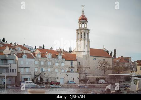 Belle église historique avec un clocher pittoresque à Sumartin, sur l'île de Brac en Croatie en hiver. Banque D'Images