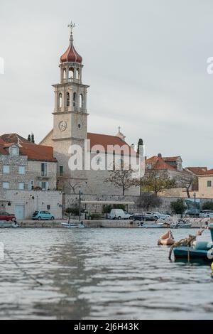 Belle église historique avec un clocher pittoresque à Sumartin, sur l'île de Brac en Croatie en hiver. Banque D'Images