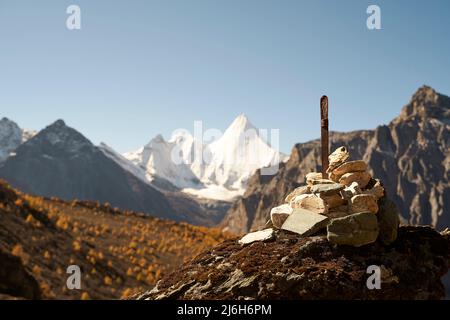 pile de pierres de prière (ou de pierres omanaises) devant le mont jampayang (ou yangmaiyong) dans le parc national de yading, comté de daocheng, province du sichuan, chine, Banque D'Images