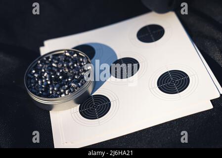 10.03.2021 Varsovie, Pologne. CO2 capsule et cible sur un plan de pose plat en matériau noir. Balles de carabine à air comprimé. Photo de haute qualité Banque D'Images