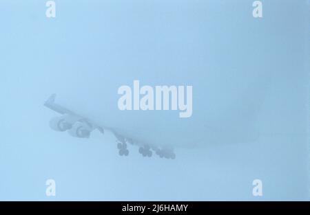 Amsterdam, vers janvier 2005. Prise de vue au téléobjectif d'un avion à réaction en brouillard épais, par une journée enneigée. Le brouillard et la glace forment des conditions difficiles pour les avions au départ. Banque D'Images