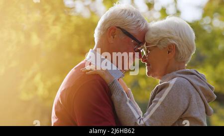 Couple caucasien âgé embrassant dans le parc d'automne. Gros plan. Front ensemble. Photo de haute qualité Banque D'Images