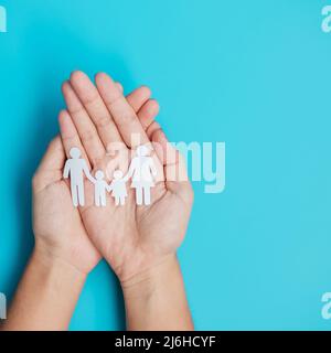 Bonne journée de la famille. Mains tenant la découpe en papier avec le Père, la mère et les enfants. Journée internationale des familles, maison chaude, sans-abri, Foster, Insur Banque D'Images