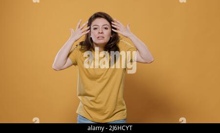 Femme nerveuse ayant une panne arguant des mains en mouvement et criant faire une scène tout en se sentant en colère et furieux en studio. Personne émotive outragée et forte qui s'est exclame en laissant la colère. Banque D'Images