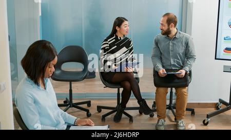 Homme et femme asiatique parlant de l'embauche et de l'emploi, attendant dans la file d'attente pour assister à la réunion d'entrevue d'emploi. Les candidats qui ont une conversation sur la nomination au recrutement et le partenariat. Banque D'Images