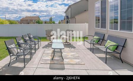 Panorama blanc nuages bouffis Grand patio extérieur avec chaises et table sur le tapis Banque D'Images